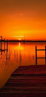 Beautiful sunset over calm lake with orange hues reflecting on water.