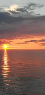 Beautiful sunset over the ocean with vibrant orange hues and tranquil reflections.