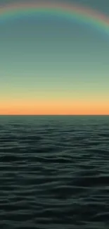 Sunset over ocean with rainbow horizon and calm waves.