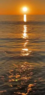 Vibrant orange sunset reflecting on tranquil ocean waters.