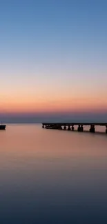 Sunset over ocean with pier silhouette creating a tranquil scene.