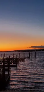 Tranquil sunset over a pier with calm water.