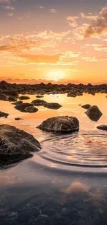 Serene sunset over rocks reflected in calm water.