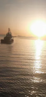 Boat silhouette under glowing sunset over calm ocean waters.