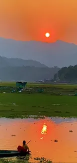 Serene sunset over tranquil water with mountain backdrop.