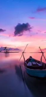 Small boat floating under a stunning pink and blue sunset.