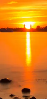 Serene sunset over a calm body of water reflecting warm orange hues.