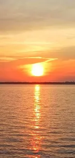 Serene sunset over water with orange and warm tones.