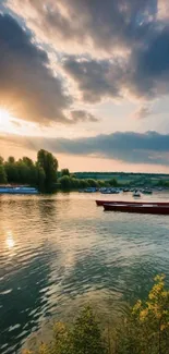 Sunset over a serene river with boats and trees reflecting in calm waters.