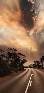 Sunset over road with dramatic sky and trees in peaceful landscape.