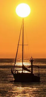 Sailboat silhouette at sunset on an orange horizon.