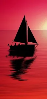 Silhouette of sailboat against vibrant sunset reflection.