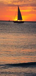 Sailboat on ocean during a vibrant sunset.