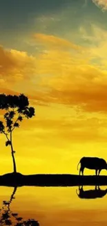 Sunset silhouette with tree and cattle reflecting in water.