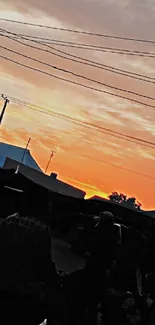 Vibrant sunset with silhouetted figures and an orange sky.