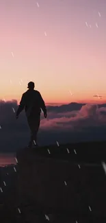 Silhouette walking against a colorful sunset sky with clouds.