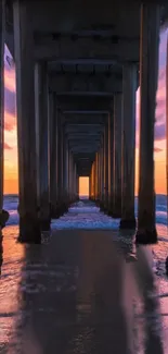 Beautiful sunset under a pier with ocean reflections.