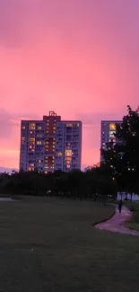 Sunset city skyline with pink sky and modern buildings.