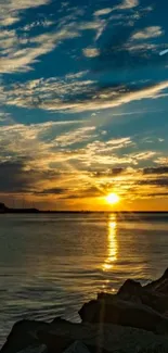 Sunset over a tranquil waterfront with vibrant sky and water reflection.