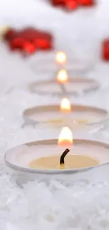 Serene arrangement of tealight candles on snow.