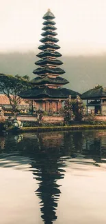 Bali temple reflecting on a tranquil lake at dawn.