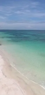 Tropical beach with turquoise water and pristine sand under a clear blue sky.
