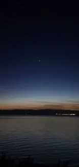 Serene twilight sky over calm water, with visible stars and a dark blue ambiance.