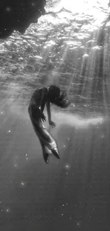 Elegant black and white underwater scene with a serene figure.