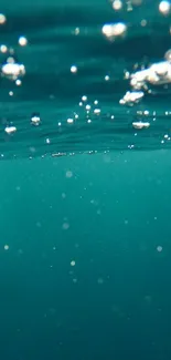 Tranquil teal underwater scene with bubbles.