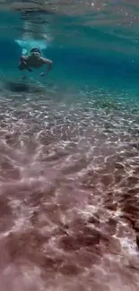 Underwater swimmer amidst sunlit ocean ripples in serene turquoise setting.