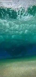 Underwater view with wave above ocean floor, in tranquil aqua hues.