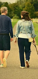 A couple and dog walking on a scenic green path under a serene sky.
