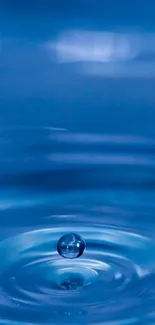 A serene water droplet and ripple on a blue background for mobile wallpaper.