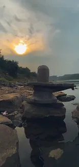 Tranquil sunset with rocks and water reflection in nature.