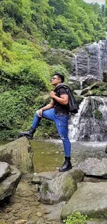 Man explores lush waterfall scenery with greenery.