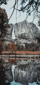 Waterfall cascading down a rocky mountain, reflecting in a tranquil lake.