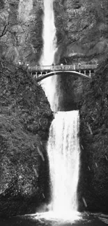 Black and white waterfall with rustic bridge scenery.