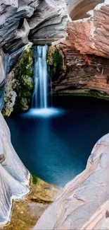 Serene waterfall cascading into a canyon with textured rock walls.