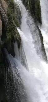 Serene waterfall cascading down rocks in a tranquil nature scene.