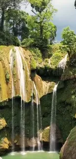 Lush forest waterfall with cascading water and bright green surroundings.