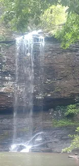 Waterfall cascading down rocks in a lush, green forest landscape.