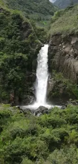 Serene waterfall flowing through lush green forest and rocky landscape.