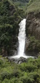 Waterfall surrounded by lush green landscape.