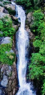 Waterfall in lush green forest with cascading water and rocky surroundings.