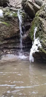 Peaceful waterfall over mossy rocks in nature scene.