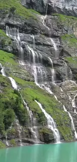 Cascading waterfalls over a lush green hillside with serene turquoise water below.