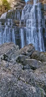 Cascading waterfall over rocky surfaces with gray stones.