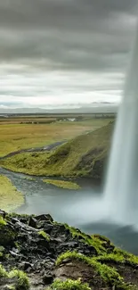 Beautiful waterfall in a lush, green landscape under a cloudy sky.