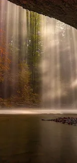 Misty waterfall framed by autumn trees and serene forest.