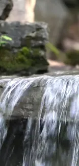 Serene waterfall over rocks with lush green moss.